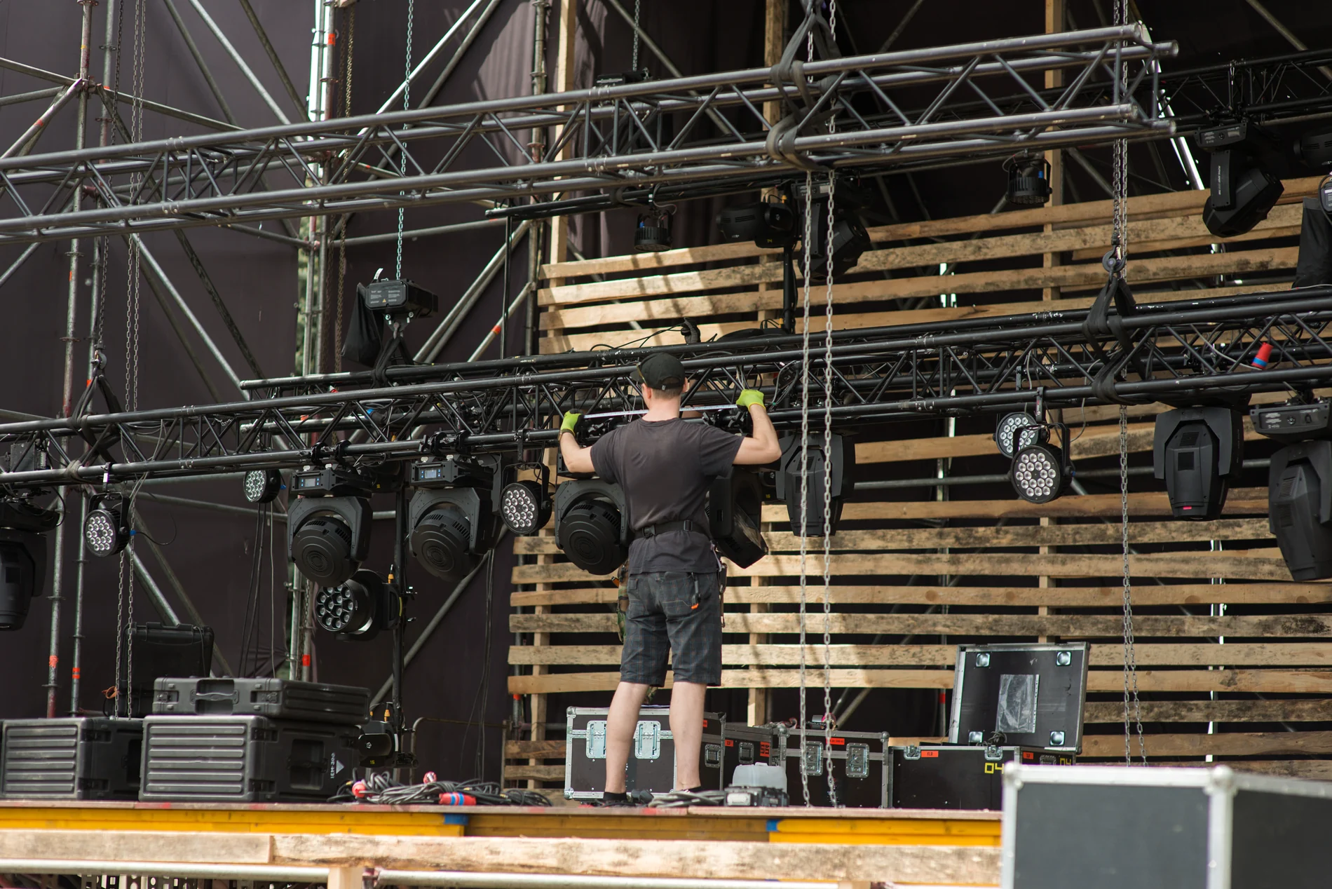 worker-assembles-lighting-equipment-mobile-stage